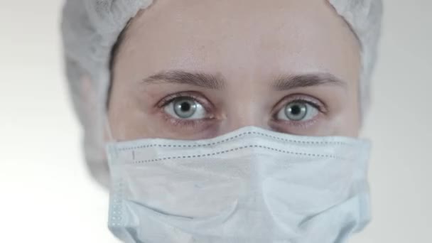 Close up of a female nurse putting on a respirator N95 mask to protect from airborne respiratory diseases such as the flu, coronavirus, ebola, TB, etc - Filmagem, Vídeo