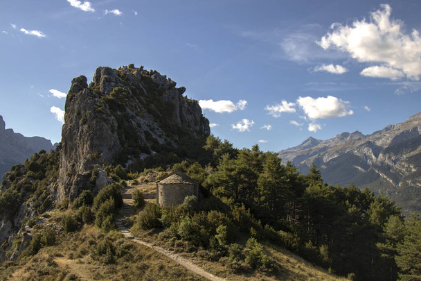 Ερμιτάζ κάτω από μια βραχώδη κορυφή στα Πυρηναία σε μια πεζοπορική διαδρομή που ονομάζεται Ermitas de Tella στην επαρχία Huesca της Ισπανίας - Φωτογραφία, εικόνα