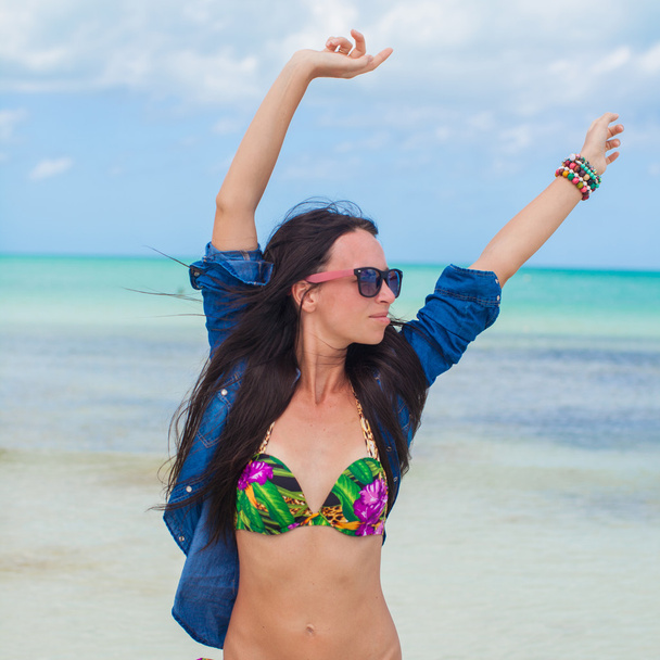 junge sexy Frau in Badeanzug und Jeansjacke hat Spaß am Strand - Foto, Bild