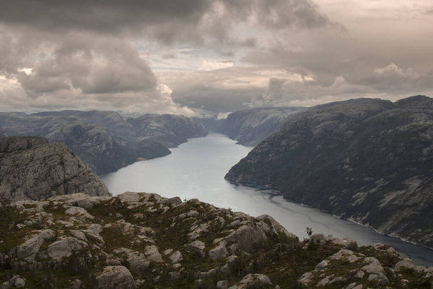 Lysefjord 'u ve etrafındaki dağları gösteren muhteşem bir manzara. Bulutlu bir gökyüzünün altında Preikestolen turist minber kayasına giden yürüyüş rotasında. - Fotoğraf, Görsel