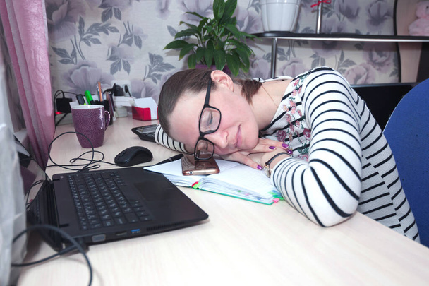 Mujer joven en gafas, se quedó en casa, cansada del trabajo y se quedó dormida. Comunicación remota y trabajo en línea
 - Foto, Imagen