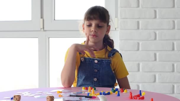 Menina sozinha joga jogos de tabuleiro em casa
 - Filmagem, Vídeo