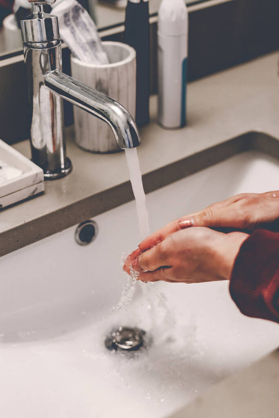 Lávate las manos con frecuencia. Jabón blanco. Baño blanco. Fregadero moderno. La cuarentena covid-19 se queda en casa. Protección contra el Coronavirus. Lávate las manos con jabón. Gotas de agua en las manos. Manos limpias. Quédate en casa.
 - Foto, imagen