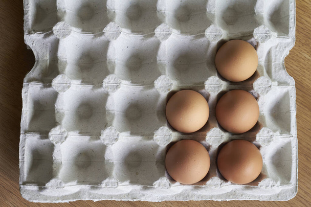 Brown eggs closeup, chicken eggs in cardboard tray on wooden table, selective focus - Photo, Image