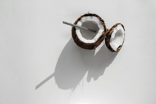 broken coconut with water on a white background. coconut milk. Top view  - Photo, Image