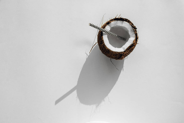 broken coconut with water on a white background. coconut milk. Top view  - Фото, зображення