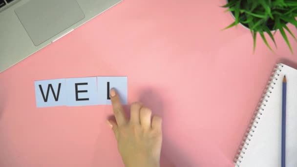 Top view time lapse letters cards leżące na różowym biurku. Słowo WELCOME - Materiał filmowy, wideo