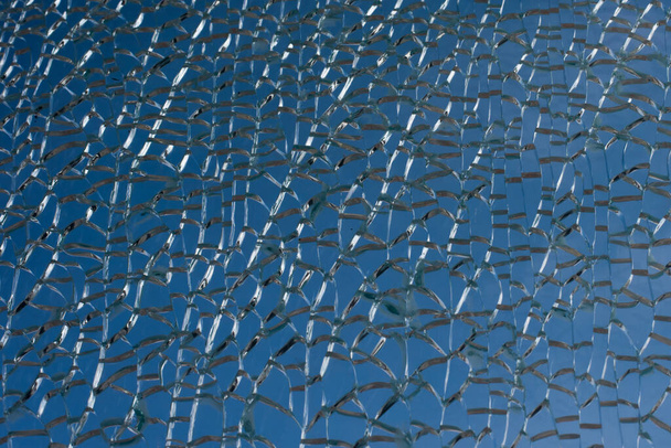 Broken glass through which the blue sky is visible - Photo, Image