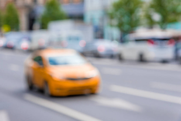 Blurred background - city road and orange taxi - 写真・画像