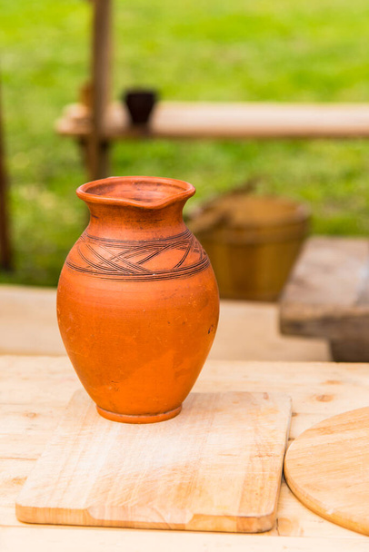 Традиционный глиняный кувшин на столе на деревенском фоне
 - Фото, изображение