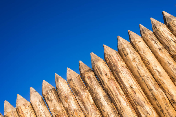 Valla de madera de troncos afilados cepillados
 - Foto, Imagen