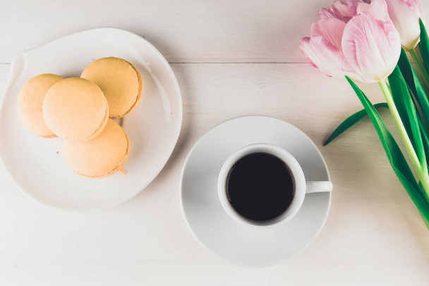 Eine Tasse Kaffee, ein Strauß Blumen und Kuchen vor hellem Hintergrund - eine Draufsicht. Glückwunsch zum Valentinstag - Foto, Bild