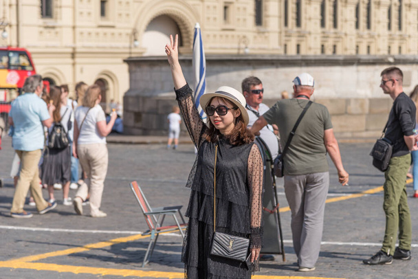Russia, Mosca 13 maggio 2018 - Attraente turista asiatico mostra un segno di vittoria con le dita
 - Foto, immagini