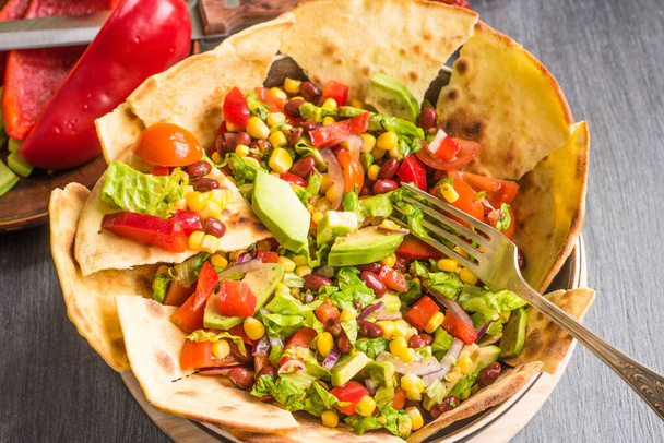 Spicy Mexican vegetarian taco salad with avocado, corn, pepper, tomatoes and beans - Photo, Image