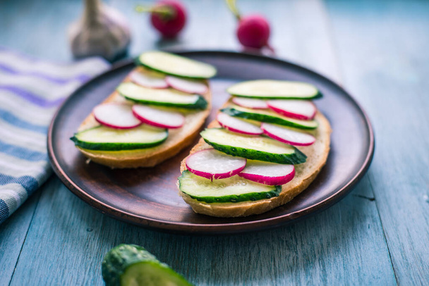 Lahodné a jednoduché vegetariánské sendviče s okurkou a ředkvičkami na rustikálním dřevěném pozadí - organické zdravé potraviny - Fotografie, Obrázek