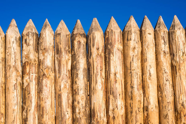 Valla de madera de troncos afilados cepillados
 - Foto, Imagen