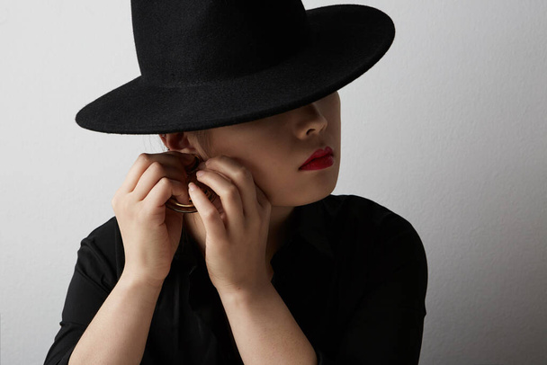 Beauty fashion portrait of sensual asian young woman wearing black hat on white background. - Foto, Imagen