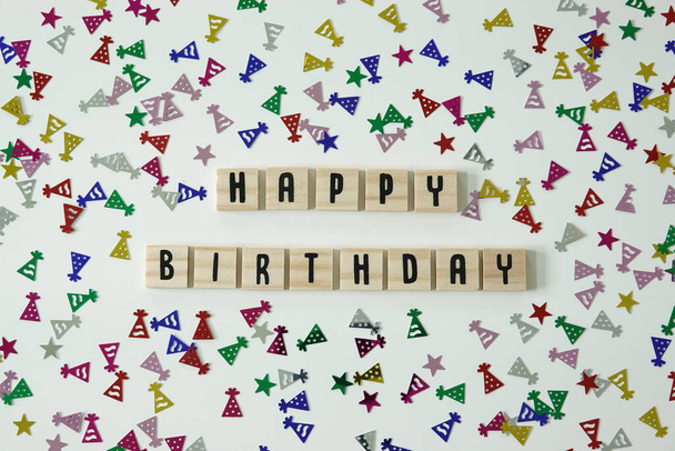 Alles Gute zum Geburtstag in hölzernen Buchstaben Kacheln mit Konfetti Geburtstagsmützen und Sterne drumherum geschrieben. - Foto, Bild