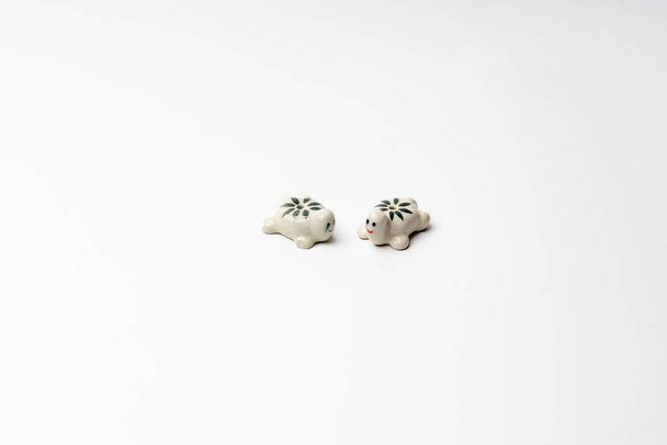 małe figury dwóch żółwi ceramicznych na białym tle - Zdjęcie, obraz