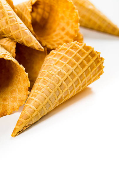 Empty Waffle Cone. Cônes de crème glacée gaufre sur fond blanc. Pâtisserie en forme de cône. Concentration sélective
. - Photo, image