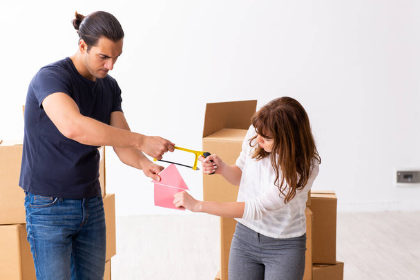 Young pair and many boxes in divorce settlement concept - Foto, afbeelding