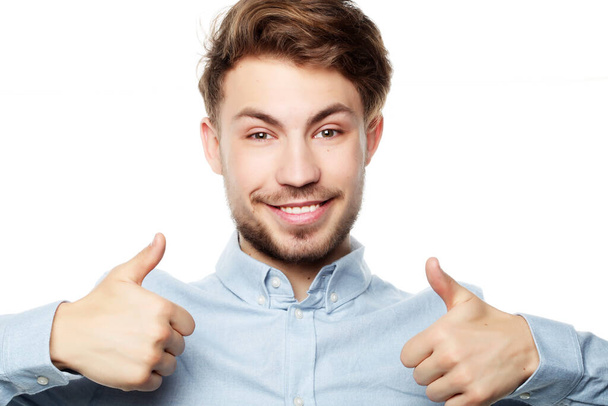 Happy smiling man showing thumb up hand sign on white background - Fotó, kép