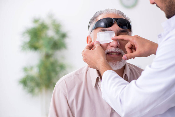 Velho cego visitando jovem médico masculino - Foto, Imagem