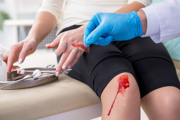 Am Bein verletzte Frau bei Arztbesuch - Foto, Bild