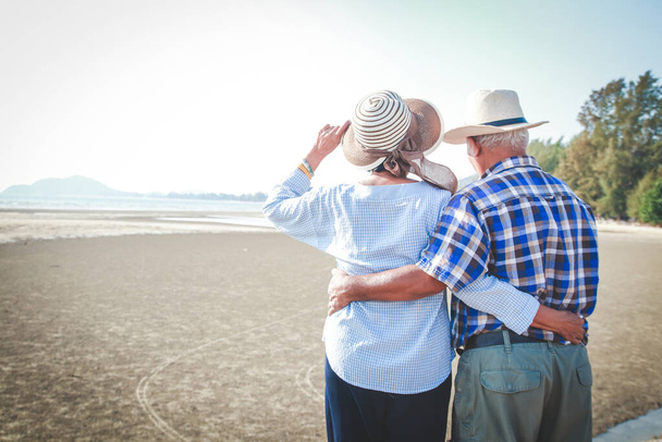 Un couple asiatique âgé se serrant dans ses bras, heureux à la mer. - Photo, image