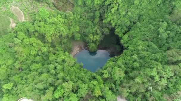 Aerial view of a heart-shaped pit filled with water and shrouded with trees and plants in Maoyanhe Scenic Aera in Zhangjiajie city, central China's Hunan province, 16 April 2020. - Footage, Video