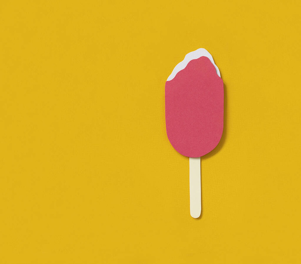 Fruit popsicle with couple of bites on yellow background. Flat lay, top view. Minimalist concept with copy space. Paper ice-cream on wooden stick. Paper craft. - Foto, Imagen