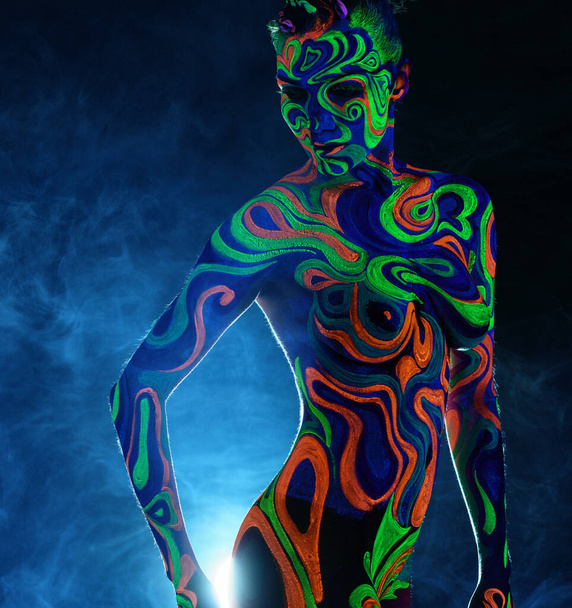 Slim woman posing nude with luminous body art - Photo, Image