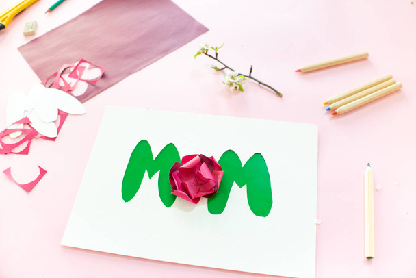 Instruction step 7. DIY greeting card as a gift for moms day with an applique with a flower made of paper. - Fotó, kép