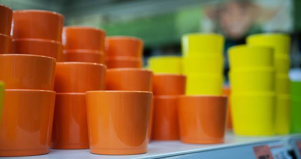 Orange and yellow flower pots on the counter in the store - Fotó, kép