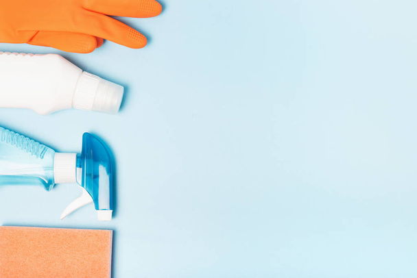 Luvas laranja e frasco de spray no espaço de cópia de fundo azul, conceito de limpeza
. - Foto, Imagem