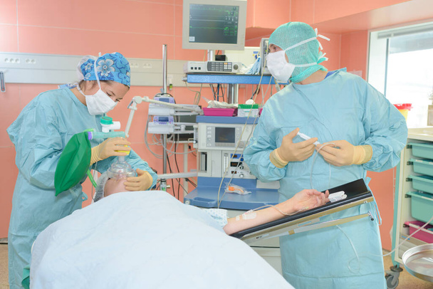 surgeons during operation and surgeon - Foto, afbeelding