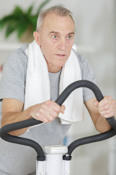 senior man working exercise on bike at gym - Foto, imagen