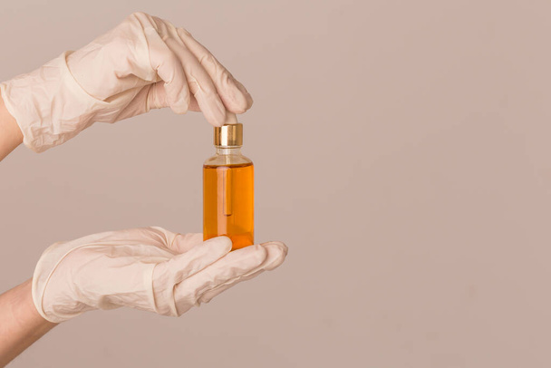 Hand holds a small bottle with oil - Foto, afbeelding