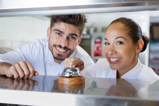 restaurant chef smiling pointing at kitchen bell - Photo, Image