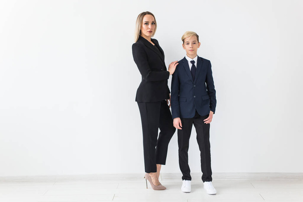 Teenager and single parent - Young mother and son standing together on white background. - Photo, Image