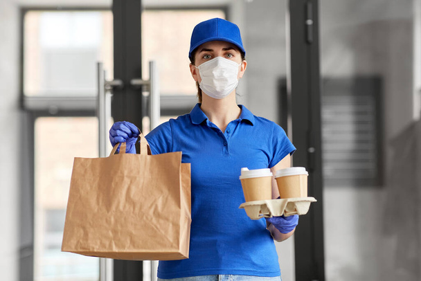 delivery woman in face mask with food and drinks - Фото, изображение