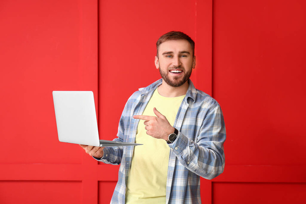 Programador masculino com laptop em fundo de cor - Foto, Imagem