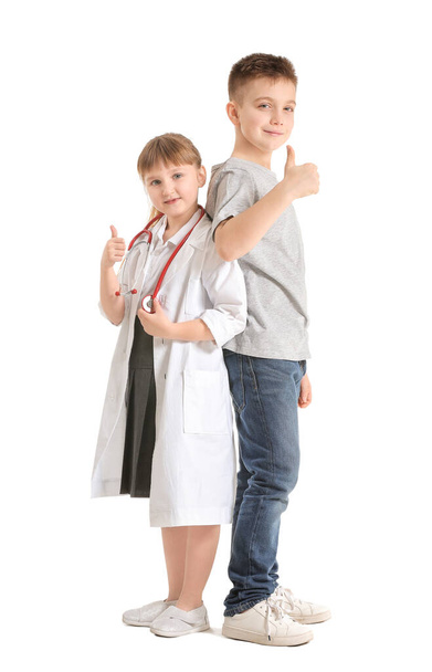 Carino piccolo medico con paziente che mostra gesto pollice su sfondo bianco
 - Foto, immagini