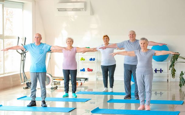 Elderly people exercising in gym - Фото, зображення