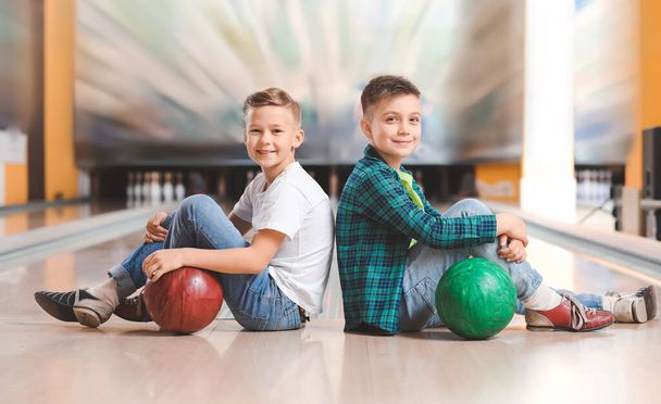 Petits garçons jouant au bowling en club
 - Photo, image