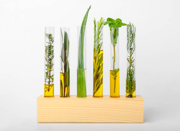 Test tubes with different essential oils on white background - Φωτογραφία, εικόνα