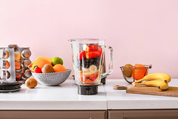 Modern blender and ingredients for healthy smoothie on kitchen table - Valokuva, kuva