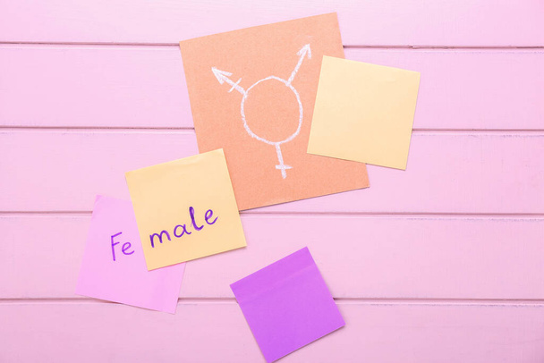 Papiery z symbolem transgenderu na drewnianym tle - Zdjęcie, obraz