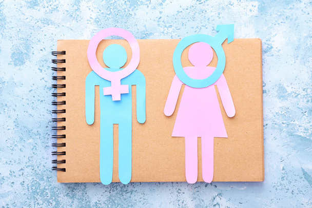 色の背景に男、女、記号の数字が書かれたノート。トランスジェンダーの概念 - 写真・画像
