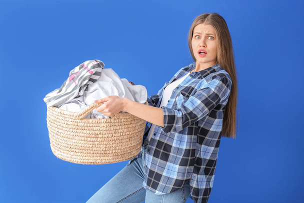 Mujer problemática con ropa sucia sobre fondo de color
 - Foto, Imagen